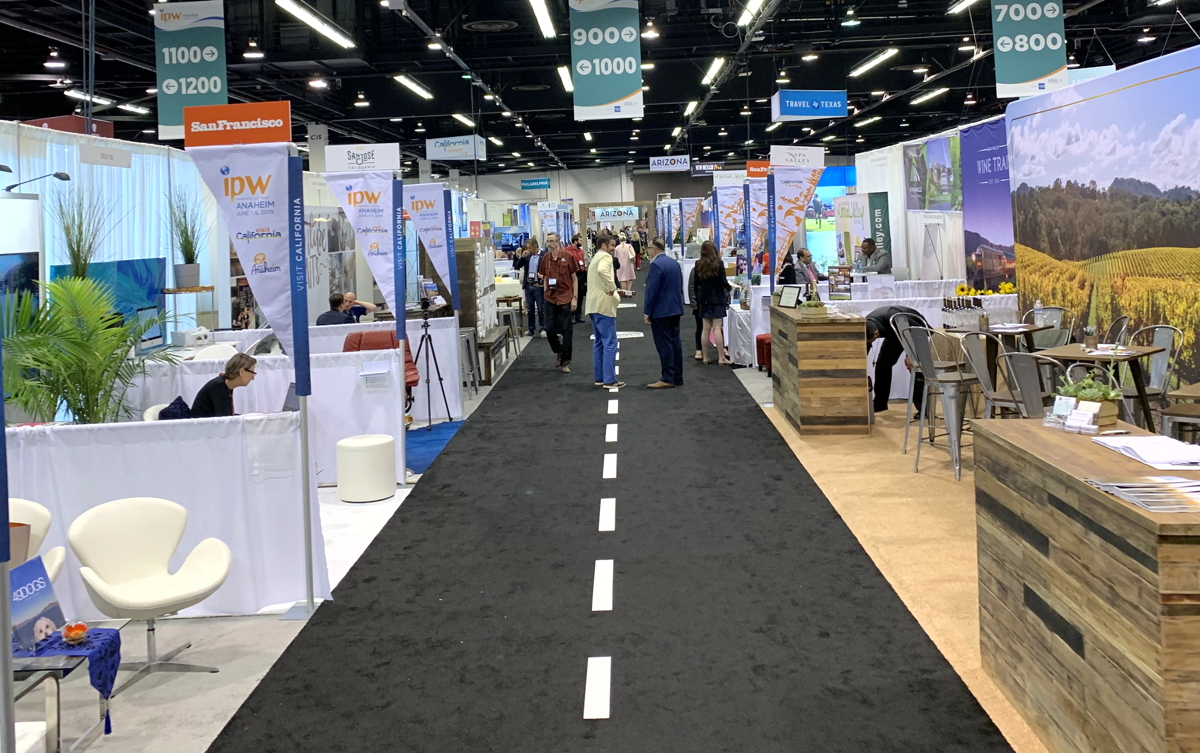 OPEN FOR BUSINESS. Into the IPW Marketplace, a sprawling space of exhibitors representing more than a thousand U.S. destinations and attractions. 