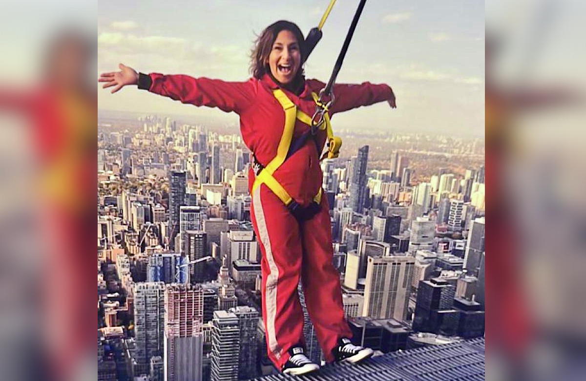 Andi hanging off Toronto's CN Tower, doing the EdgeWalk. (Supplied)